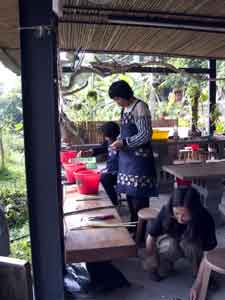 Volunteers beating cooked fiber into pulp